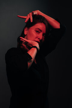 dancing woman lit by red neon light, studio shot