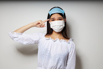 Fototapeta na wymiar pretty brunette two medical masks on the head protection isolated background unaltered