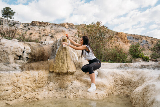 Woman taking water in mountains