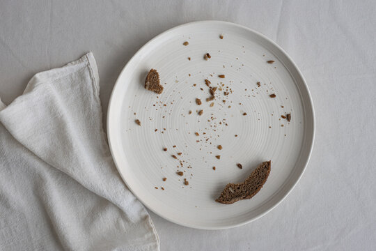 Plate and dishcloth with bread scraps on the table.