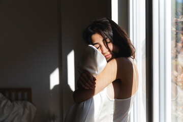 Serene woman hugging the pillow