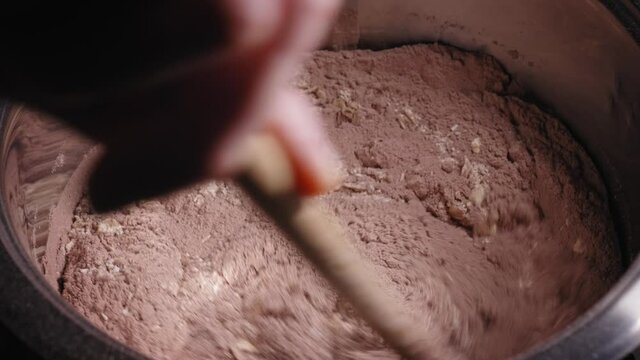Stirring Ingredients Of Protein-rich Choco Oat Cake With Wooden Spoon In A Pot. close up
