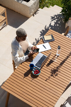 Black freelancer working on summer terrace