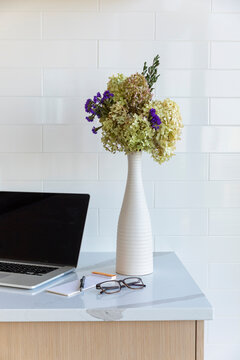 Laptop on kitchen counter in modern stylish home 