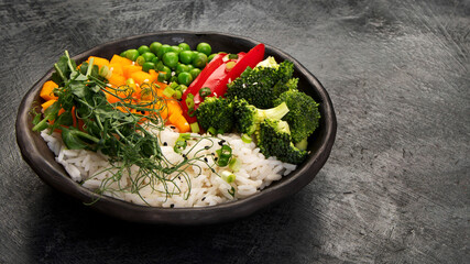 Bowl with rice, broccoli , pumpkin and microgreens.
