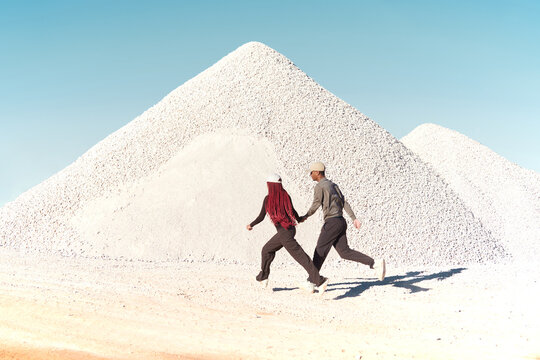 Couple running next to a white rocks mountain