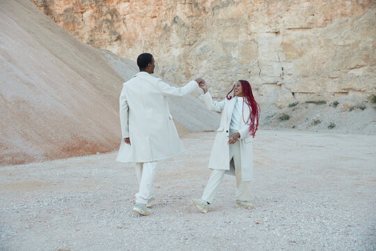 A happy black couple running outdoors