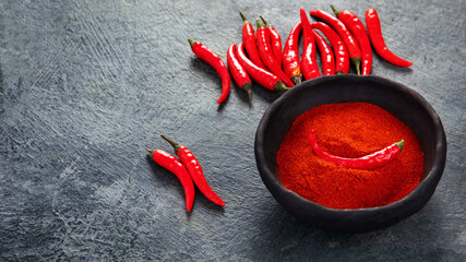 Red chili or chilli cayenne pepper on dark background. - obrazy, fototapety, plakaty