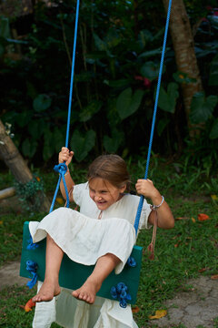 Girl frolics on a swing