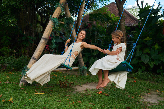 Mother with daughter on the swing