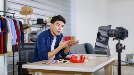 Adult asian seller man look intend holding looking at camera to present product via live online for shopping online with e-commerce sell.