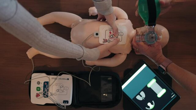 Demonstration Of Cardiopulmonary Resuscitation, CPR Procedure For Infants. - high angle