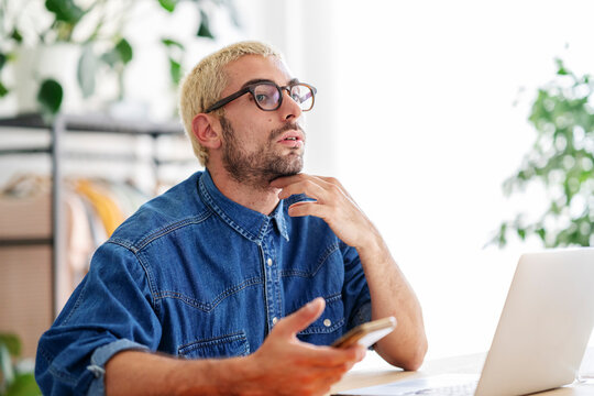 Thoughtful man with laptop in office