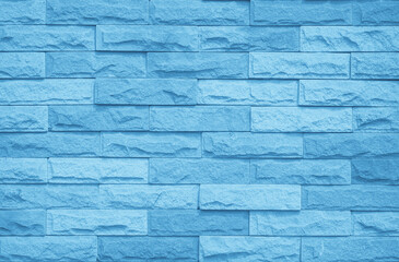 Obraz premium Brick wall painted with blue dark paint pastel calm tone texture background. Brickwork and stonework flooring interior rock old pattern clean concrete grid uneven bricks design stack backdrop.