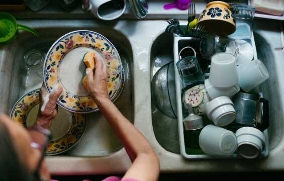 Woman doing dishes on doble sink from above