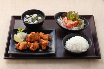 karaage rice set japanese deep fried chicken with miso soup and vegetable salad in tray on wooden background.