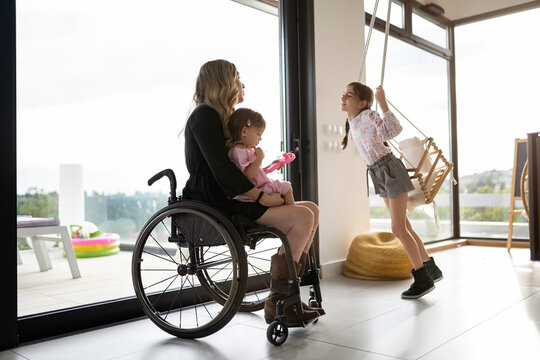 Mother in wheelchair playing with her daughters