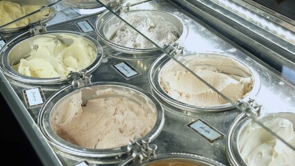 Variety of ice cream gelato range on the cafeteria shelf, pastel colors ice-cream flavors in the refrigerator