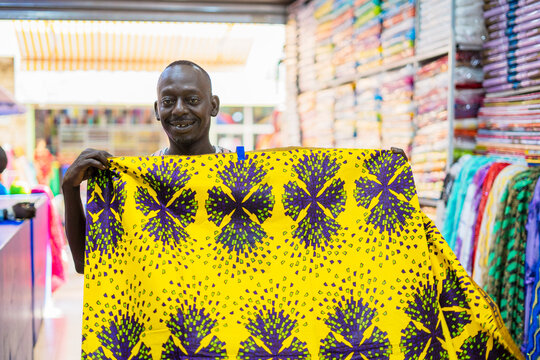 Positive black salesman folding fabric