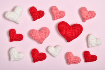 Fototapeta premium A bunch of hearts of different colors in a row lies on a pink background. Background for Valentine's Day.