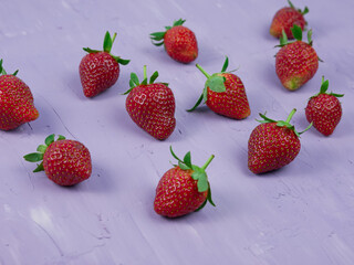 Strawberries on a purple background. healthy and vegetarian fruit concept