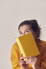 A beautiful, mysterious woman with a yellow book. Front view.