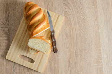 Sliced bread made of high-quality white flour on a cutting wooden board.