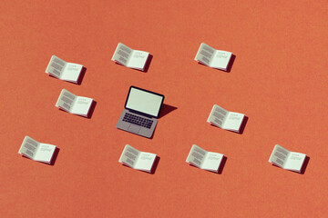 Laptop white screen surrounded by Many books on an orange