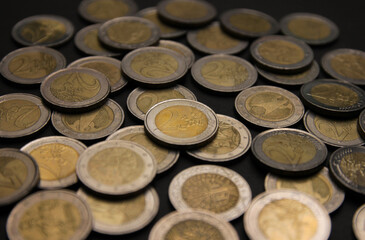 Coins of two euro on black background. Currency of the European Union.