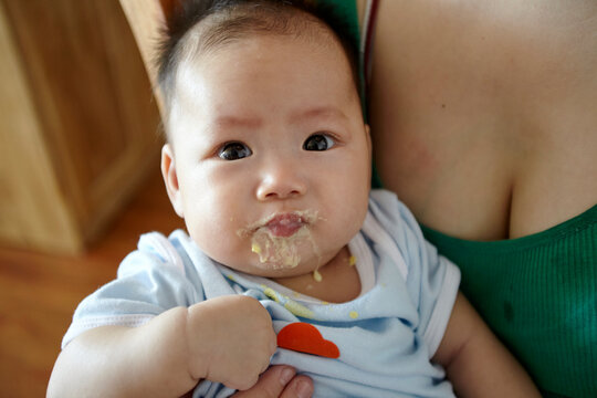 Closeup of Asian baby eating complementary food
