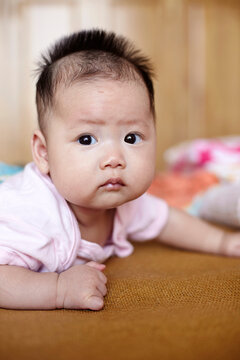 Closeup of Asian baby lying on the bed

