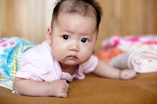Closeup of Asian baby lying on the bed

