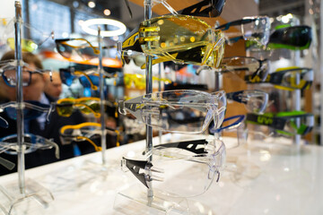 Fototapeta na wymiar Protective workers eyewear glasses on stand in the shop