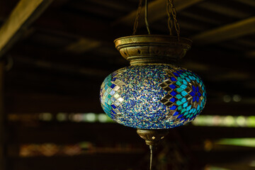 Obraz premium Lamps hanging from the ceiling, mosaic round lamp in wooden interior.