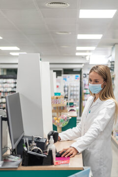 Pharmacist working at computer in pharmacy