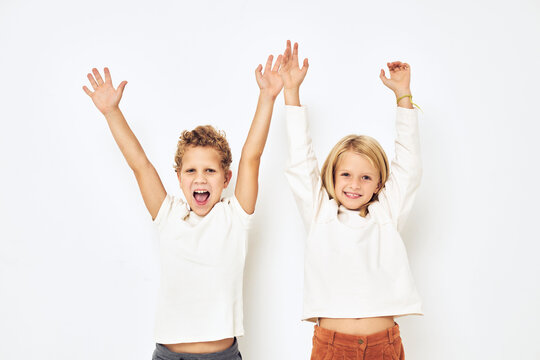 Two preschool children boy and girl gesticulate with their hands isolated background