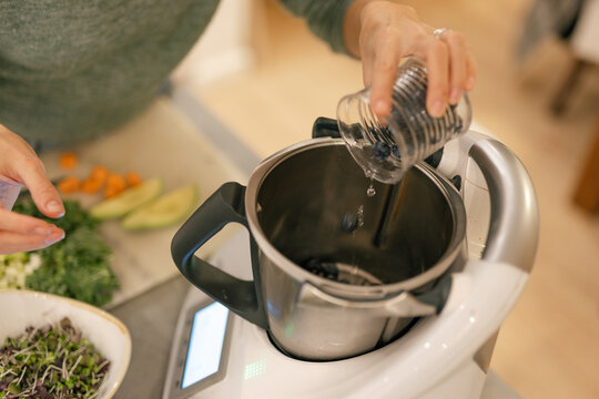 Adding parsley to kitchen robot to prepare juice