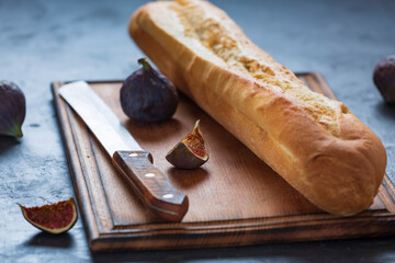 FRESH CRUNCHING BAGUETTE AND FIGS IN CLOSEUP ON TABLE