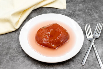 Quince dessert with syrup on a dark background. Traditional Mediterranean cuisine delicacies. Turkish Ramadan dessert. Horizontal view. Close up