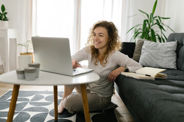 Young smiling freelancer using laptop at home