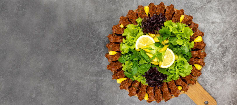 Raw meatballs (cig kofte) on a dark background. Traditional Turkish cuisine delicacies. Top view. Empty space for text. Copy space