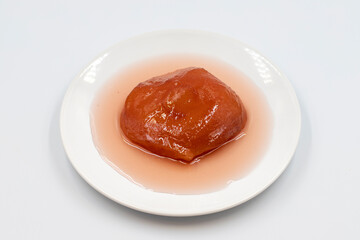 Quince dessert with syrup on white background. Traditional Mediterranean cuisine delicacies. Turkish Ramadan dessert. Horizontal view. Close up