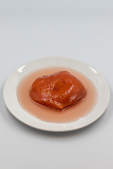 Quince dessert with syrup on white background. Traditional Mediterranean cuisine delicacies. Turkish Ramadan dessert. Vertical view. Close up