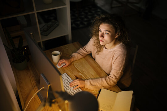 Young woman working from home during night