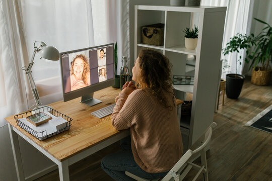 Young woman FaceTiming using desktop computer at home