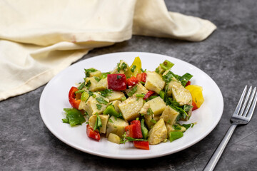 Artichoke salad with olive oil on dark background. Traditional delicious Turkish food; (zeytinyagli enginar). Horizontal view. Close up