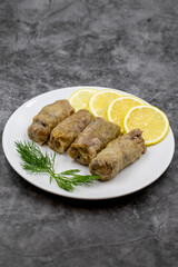 Stuffed cabbage leaves, in a ceramic plate. Vegan cabbage rolls, cooked cabbage leaves, wrapped around a filling of rice, onions and spices. (Lahana sarması) Vertical view. Close up