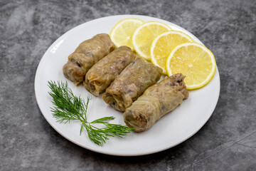 Stuffed cabbage leaves, in a ceramic plate. Vegan cabbage rolls, cooked cabbage leaves, wrapped around a filling of rice, onions and spices. (Lahana sarması) Horizontal view. Close up