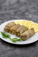 Stuffed cabbage leaves, in a ceramic plate. Vegan cabbage rolls, cooked cabbage leaves, wrapped around a filling of rice, onions and spices. (Lahana sarması) Vertical view. Close up