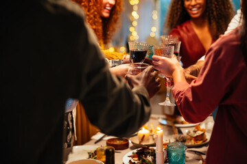 Crop people clinking wineglasses during party
